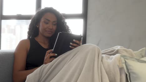 beautiful young black woman sofa relaxing happy smiling reading book close