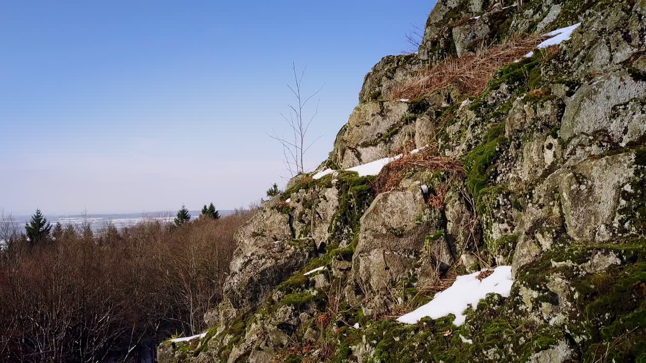 la cámara se eleva cerca de la cima de una montaña pedregosa y revela una pequeña ciudad europea