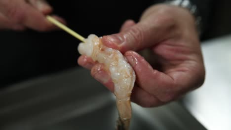 preparing shrimp on wooden skewers