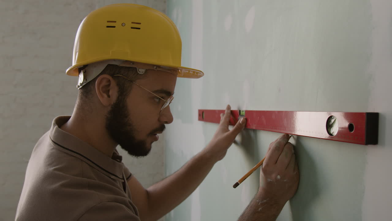 Man using level on wall