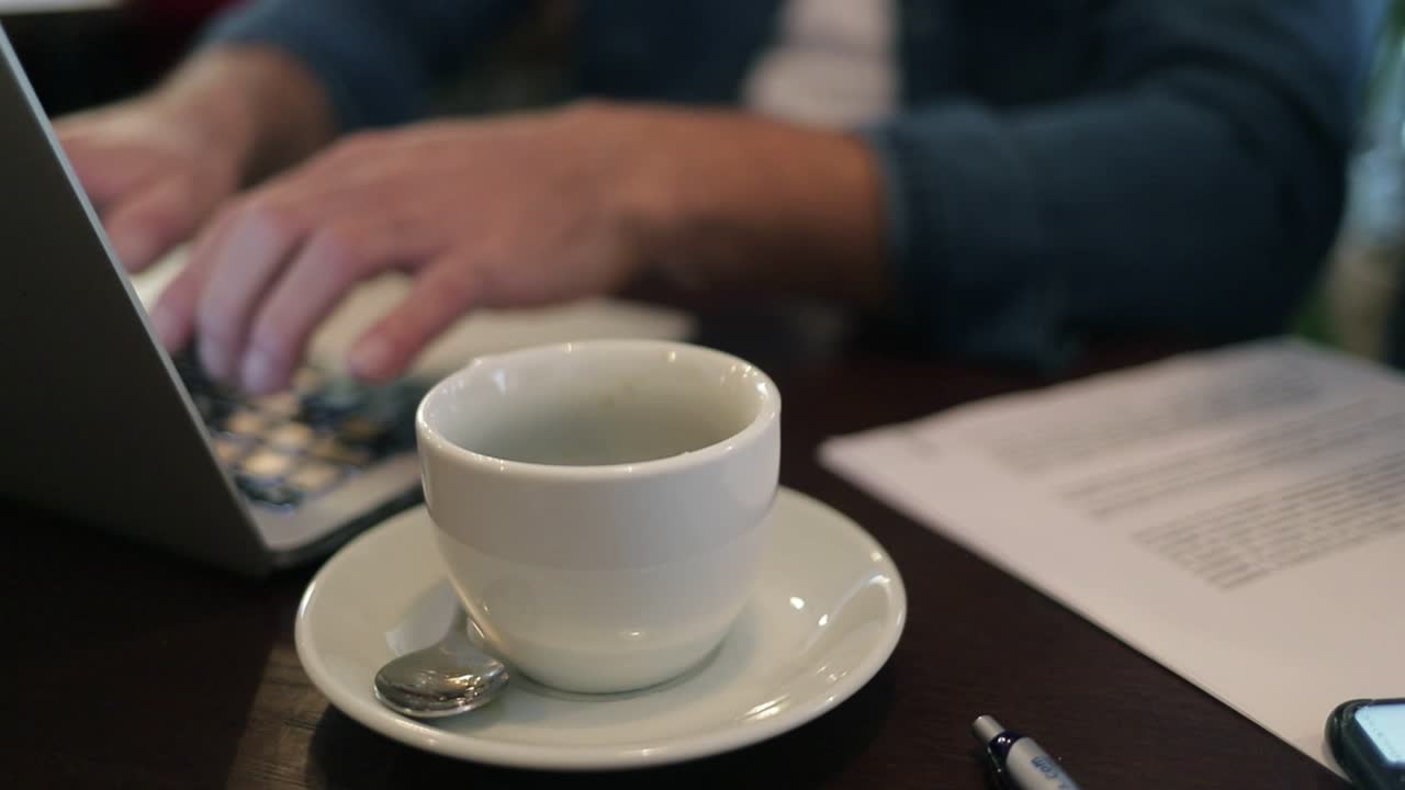 taza de café y freelancer usando una computadora portátil