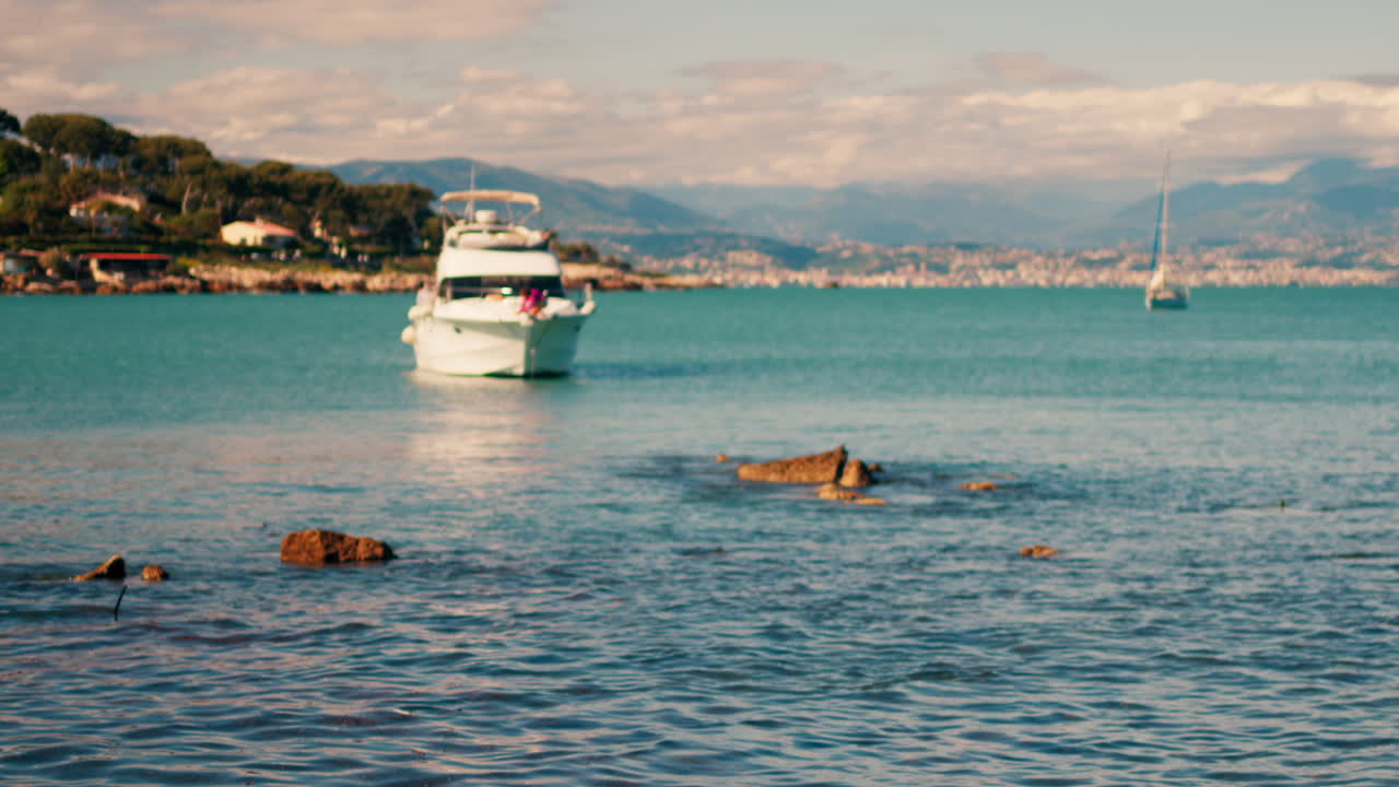 Boat floating on the sea with the town of Bandol, France on the background
