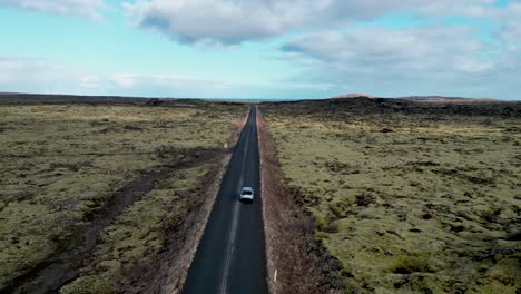 experience icelandic landscapes from a drone above, view of a car tackle winding roads through volcanic terrain, conquering obstacles on an adventure.
