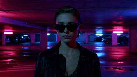 woman in sunglasses in a neon-lit parking garage