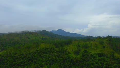 A-drone-shot-advancing-towards-a-majestic-tropical-mountain-range-on-a-moody,-cloudy-day