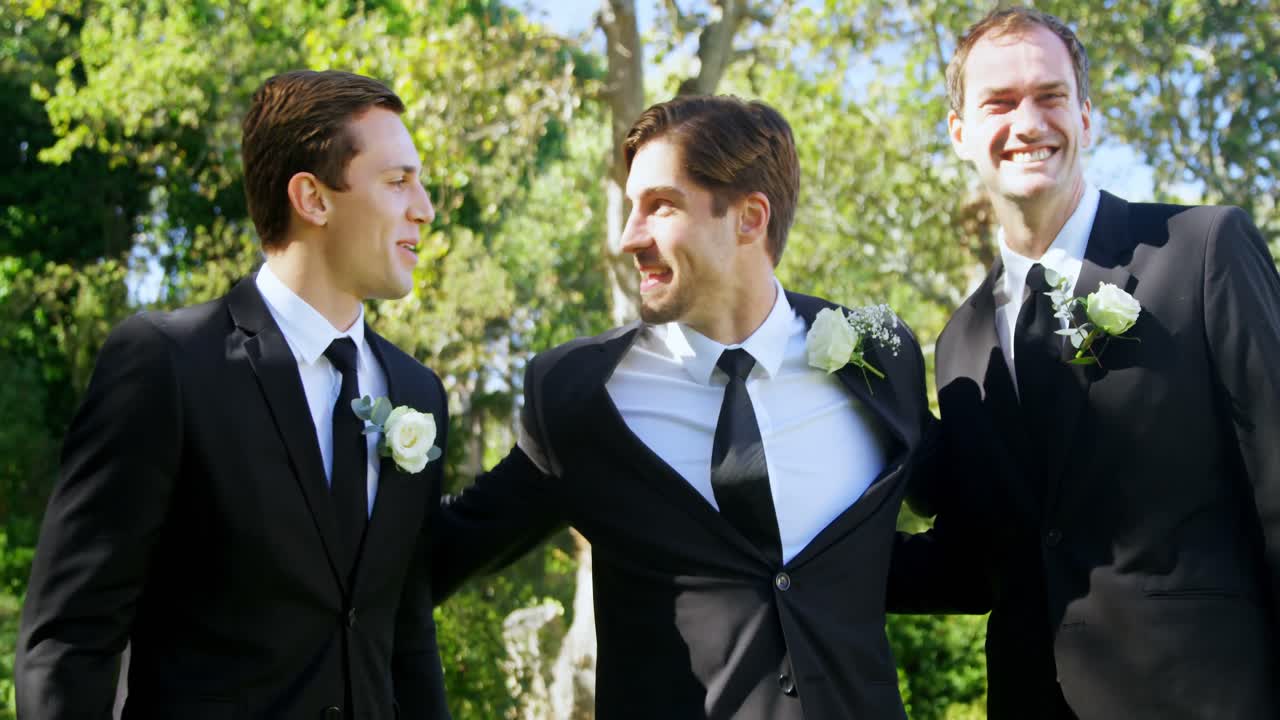 세 남자가 결혼식에서 서로 포옹하면서 행복합니다. 4k 4k