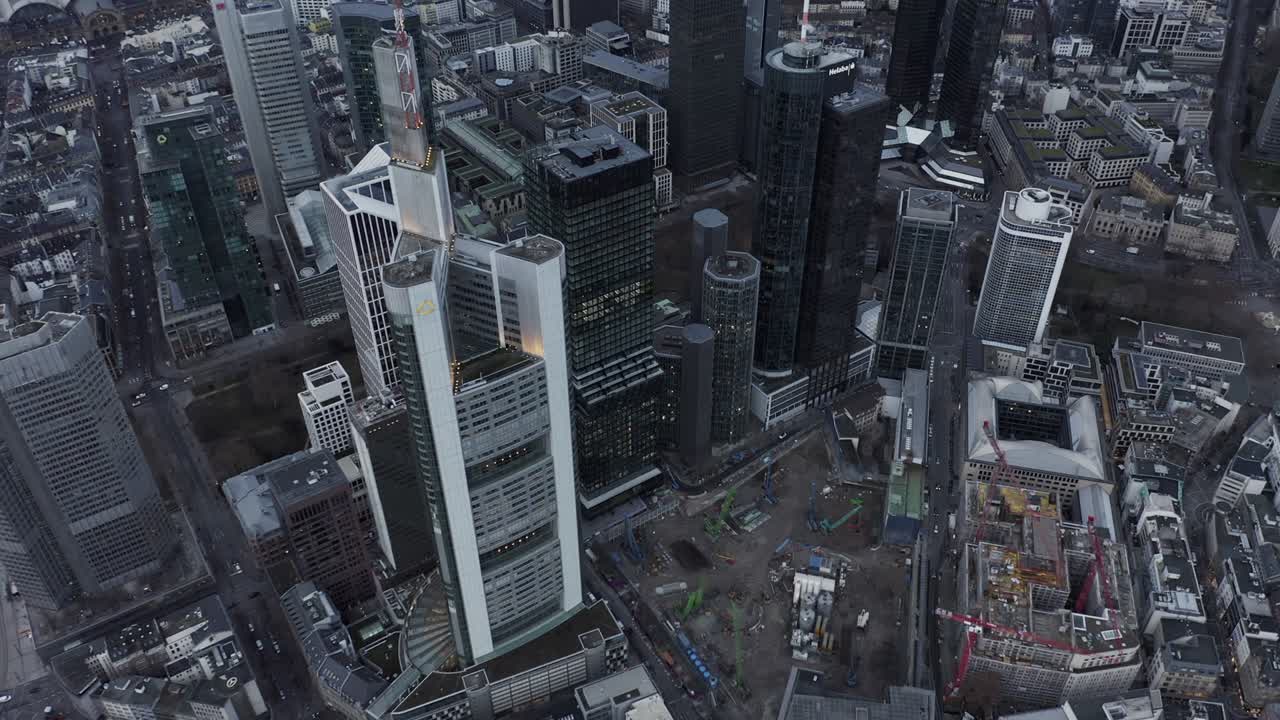 Voo sobre a cidade. Vista aérea de canteiro de obras ao lado de um grupo de arranha-céus modernos e altos em distrito comercial. Frankfurt am Main, Alemanha.