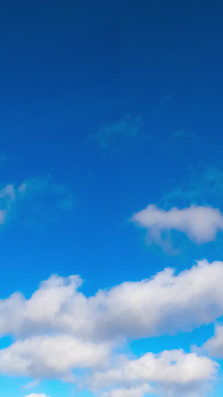 Fantastic azure sky with white clouds flying quickly by. Summer sky timelapse. Low angle view. Vertical video