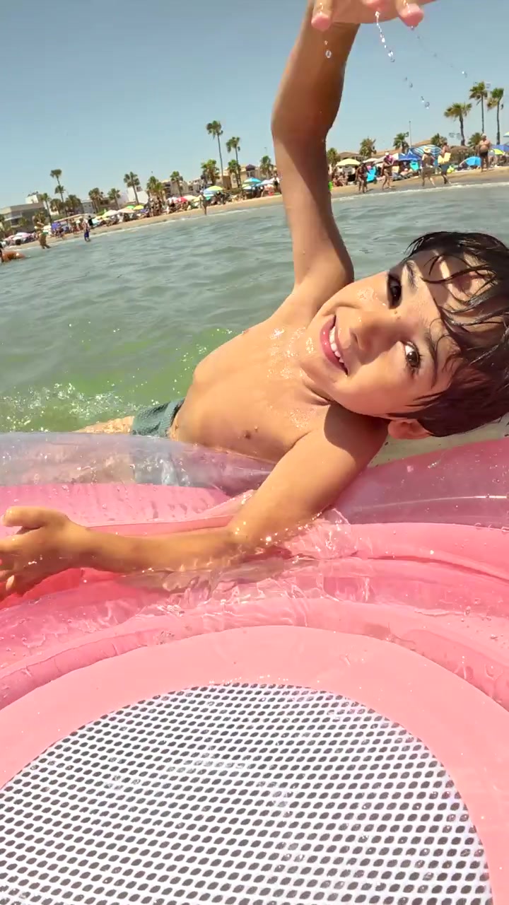 Happy Young Boy Playing on Inflatable Float in the Ocean