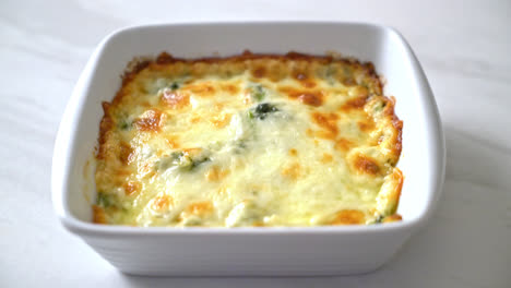 Lasaña de espinacas al horno con queso en placa blanca.