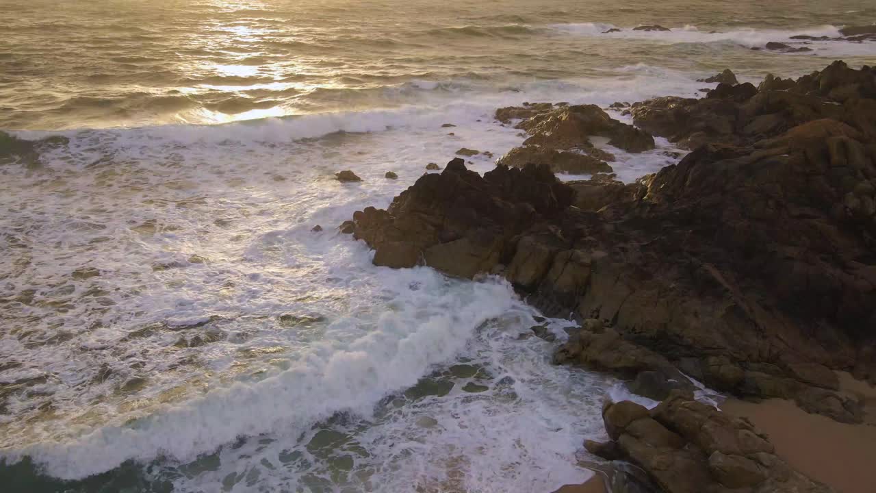 Onde dell'oceano che si infrangono contro una spiaggia rocciosa