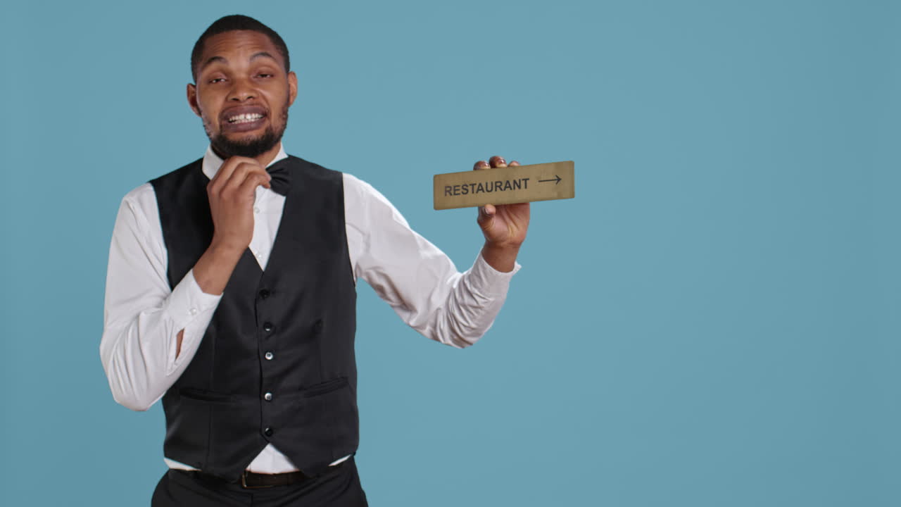 Doorman bellhop showing the restaurant direction with a hotel sign