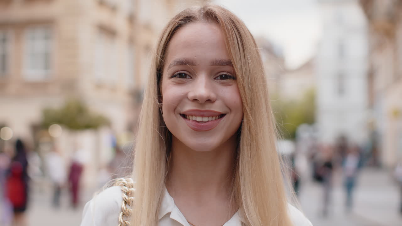 feliz mujer joven sonriendo mirando lejos soñando descansando buenas noticias sentirse satisfecho en la calle de la ciudad