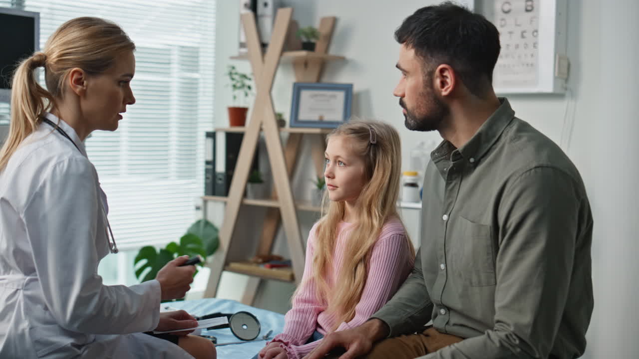 Professional doctor discussing diagnosis with with father daughter in clinic