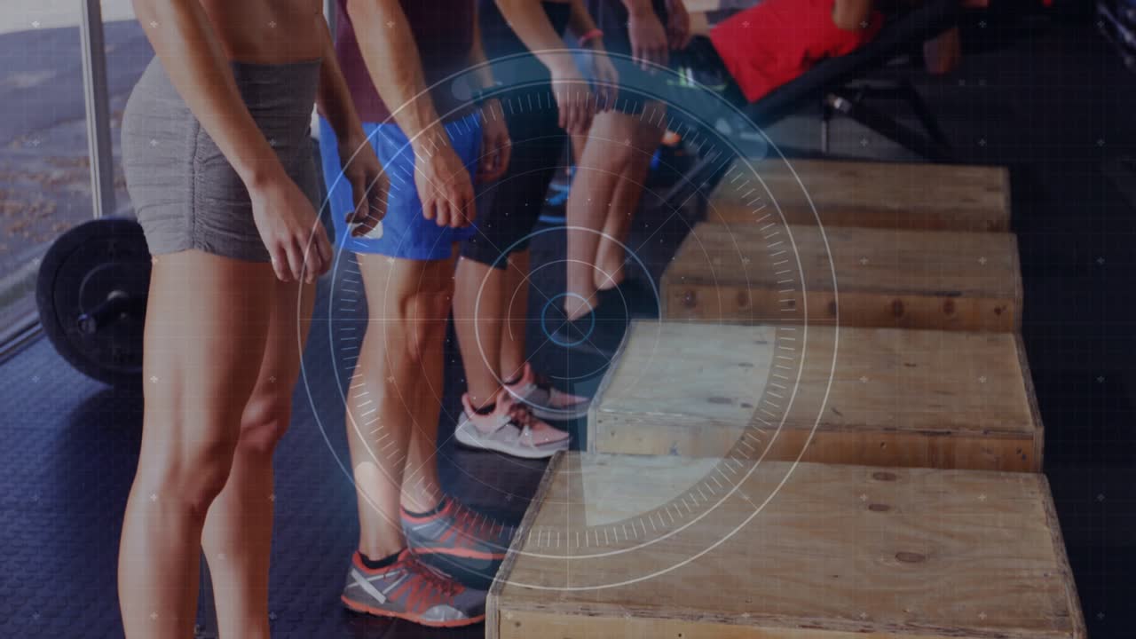 Group on instructor cue stepping onto plyo boxes and squatting for fitness, HUD tracking reps