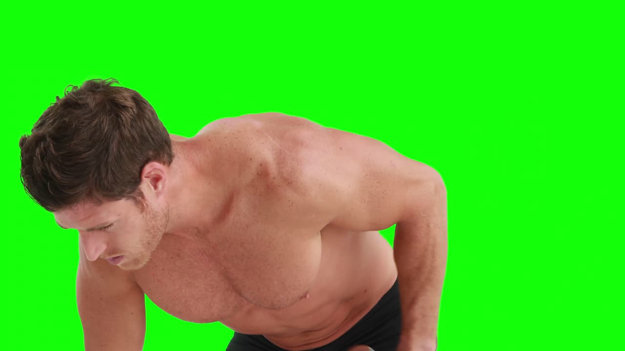 심각한 근육 남자가 덤벨을 들어 올리고 있습니다.