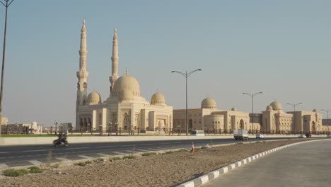 Exterior-De-La-Mezquita-De-La-Universidad-Al-Qasimia-Contra-El-Cielo-Azul-A-Lo-Largo-De-La-Vía-Urbana-En-Sharjah,-Emiratos-árabes-Unidos