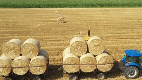 above view of agricultural field, collecting round bales of straw