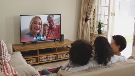 African-american-family-having-a-video-call-on-tv-while-sitting-on-the-couch-at-home