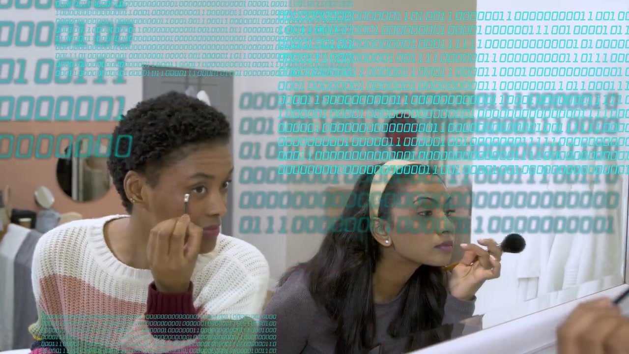 Two women reaching brushes applying makeup for beauty prep at vanity, binary overlay scanning faces
