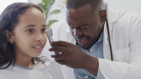 diverso médico examinando a una paciente enferma con otoscopia en el hospital en cámara lenta.