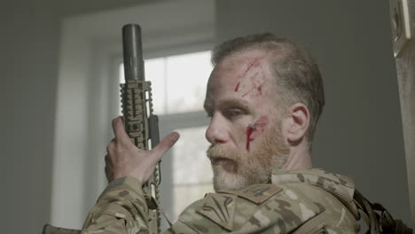 serious soldier with blood on face taking sight