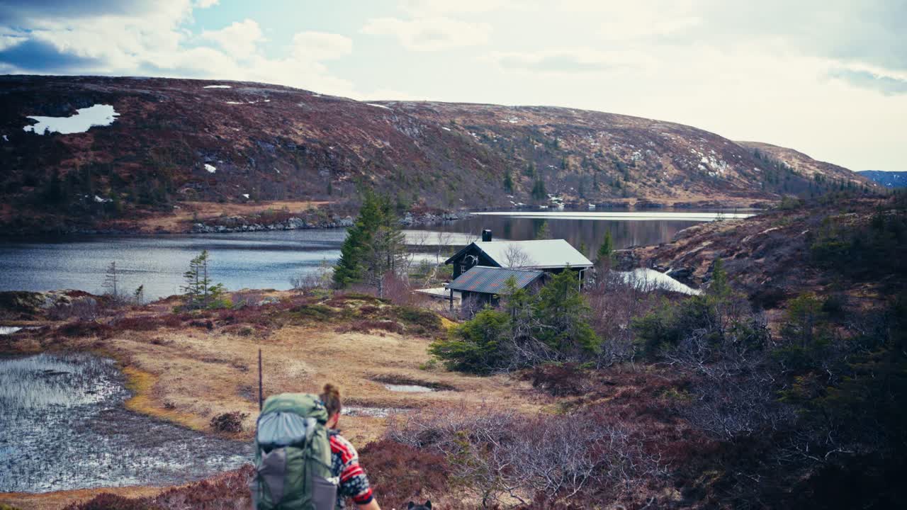 Hiker With His Dogs Walking Towards Reinsjoen Lake In Norway - Wide Shot