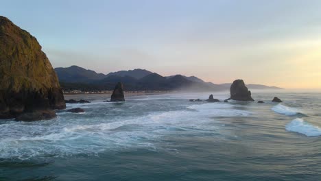 rocks sea stacks at canon beach oregon with waves crashing, aerial view