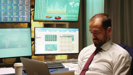 Businessman-wearing-suit-and-tie-working-on-laptop