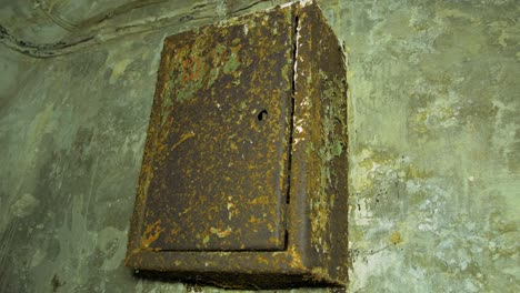 vieja caja de fusibles eléctricos oxidados dentro del refugio antibombas de hormigón para ocultar a la gente civil, un búnker subterráneo de apocalipsis construido en una antigua fortificación costera, tiro medio de cierre de mano