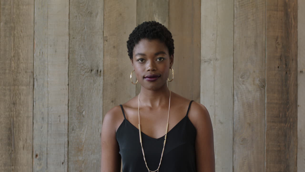 portrait of young independent african american woman looking at camera confident black female wooden lobby background
