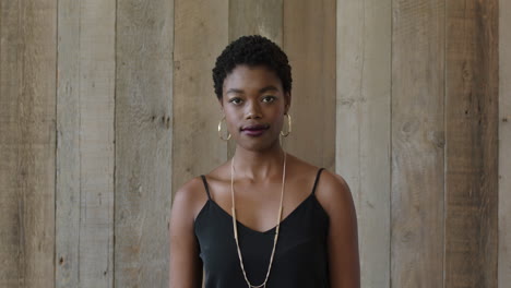 Retrato-De-Una-Joven-Afroamericana-Independiente-Mirando-La-Cámara-Confiada-En-El-Fondo-Del-Vestíbulo-De-Madera-De-Una-Mujer-Negra