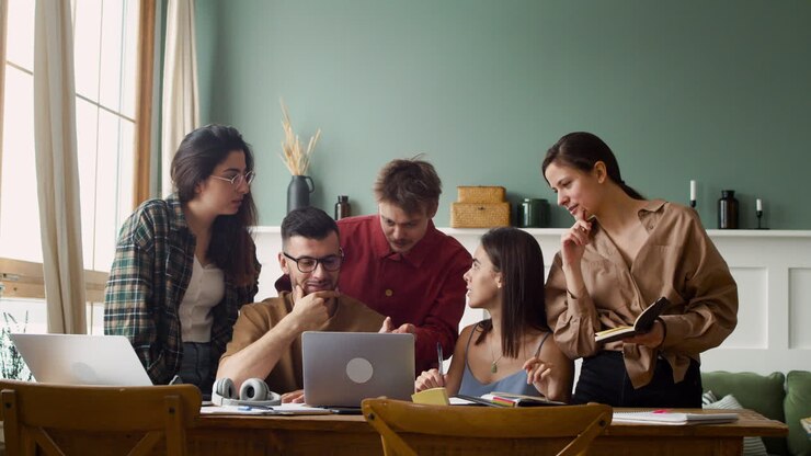 Studiegruppe ved et bord stående og siddende derhjemme 1