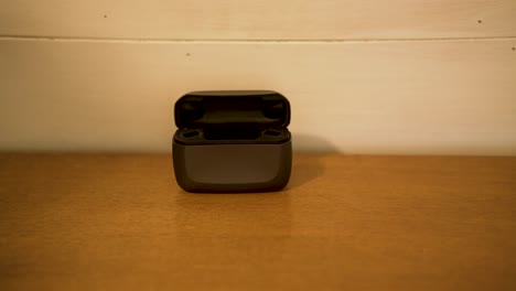 a man puts his hearing aids in the recharging station - isolated