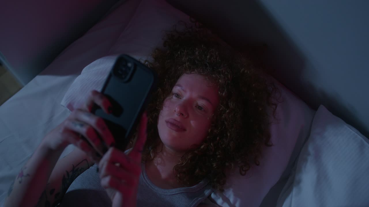 mujer usando el teléfono en la cama por la noche
