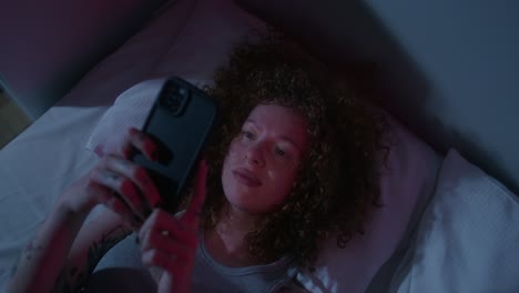 mujer usando el teléfono en la cama por la noche