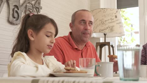 man talking to a girl while having breakfast at home