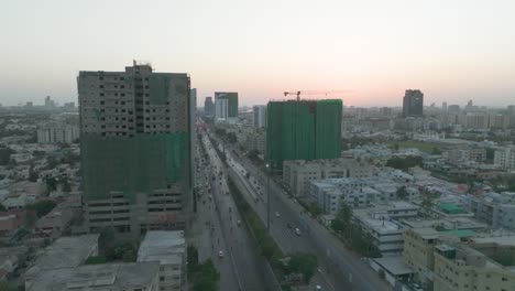 aerial shot of highway running through chorangi in karachi with residential apartments under construction