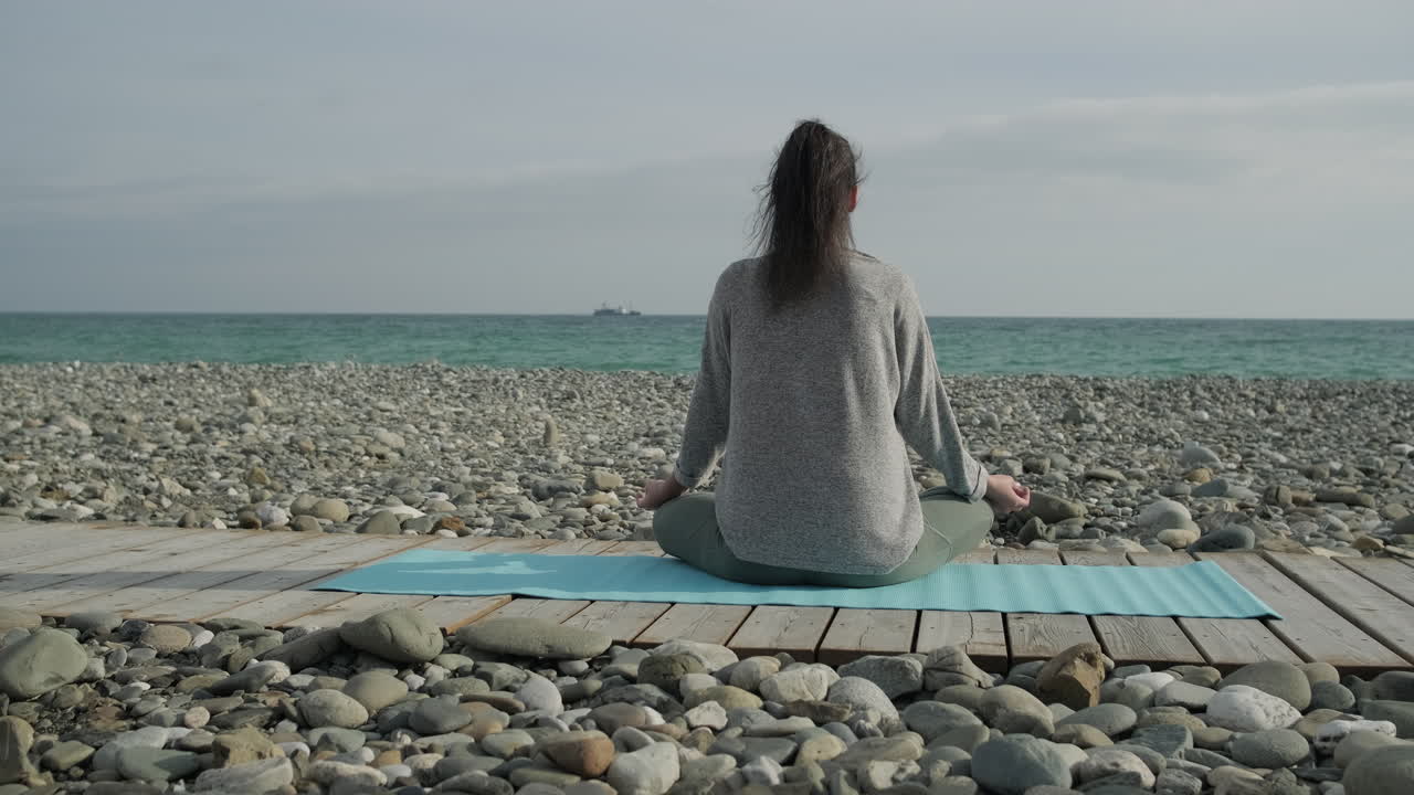 mujer meditando en una playa