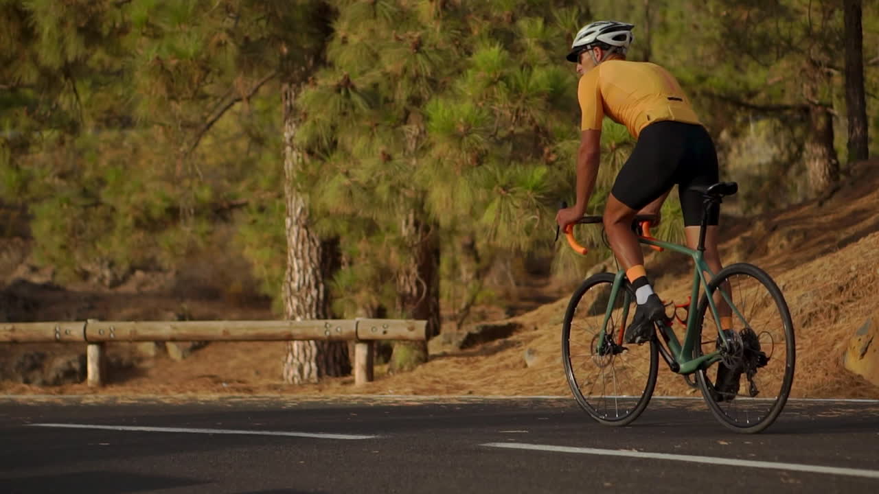 In slow motion, on a mountain serpentine, the athlete cyclist gazes at the island's beauty, symbolizing the dedication to a healthy lifestyle