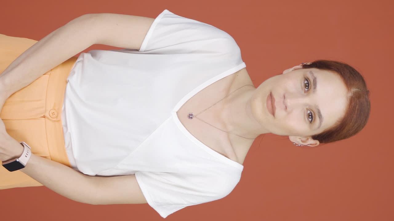 video vertical de una mujer mirando a la cámara con una expresión curiosa.