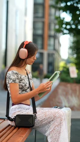 mujer joven al aire libre con auriculares y tableta