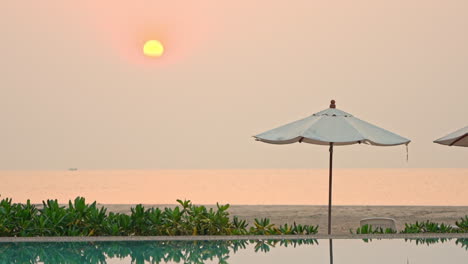 Una-Puesta-De-Sol-Rosa-Y-Amarilla-Sobre-Una-Sombrilla-De-Playa