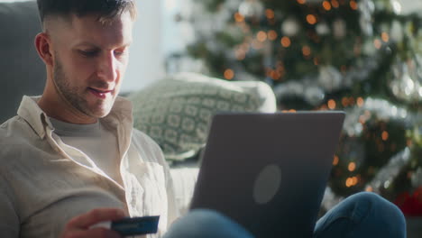 man shopping for christmas with credit card and laptop