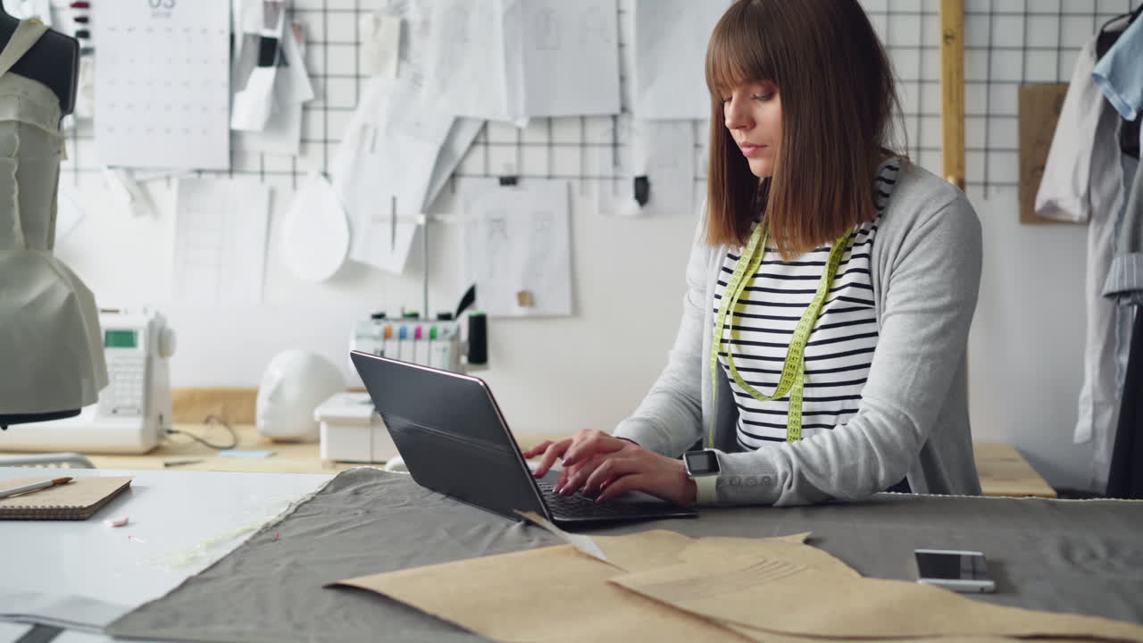 Fashion Designer Working on Laptop in Atelier
