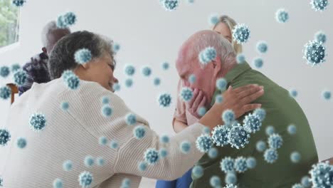 Animation-of-covid-19-cells-over-senior-woman-talking-to-senior-man-crying