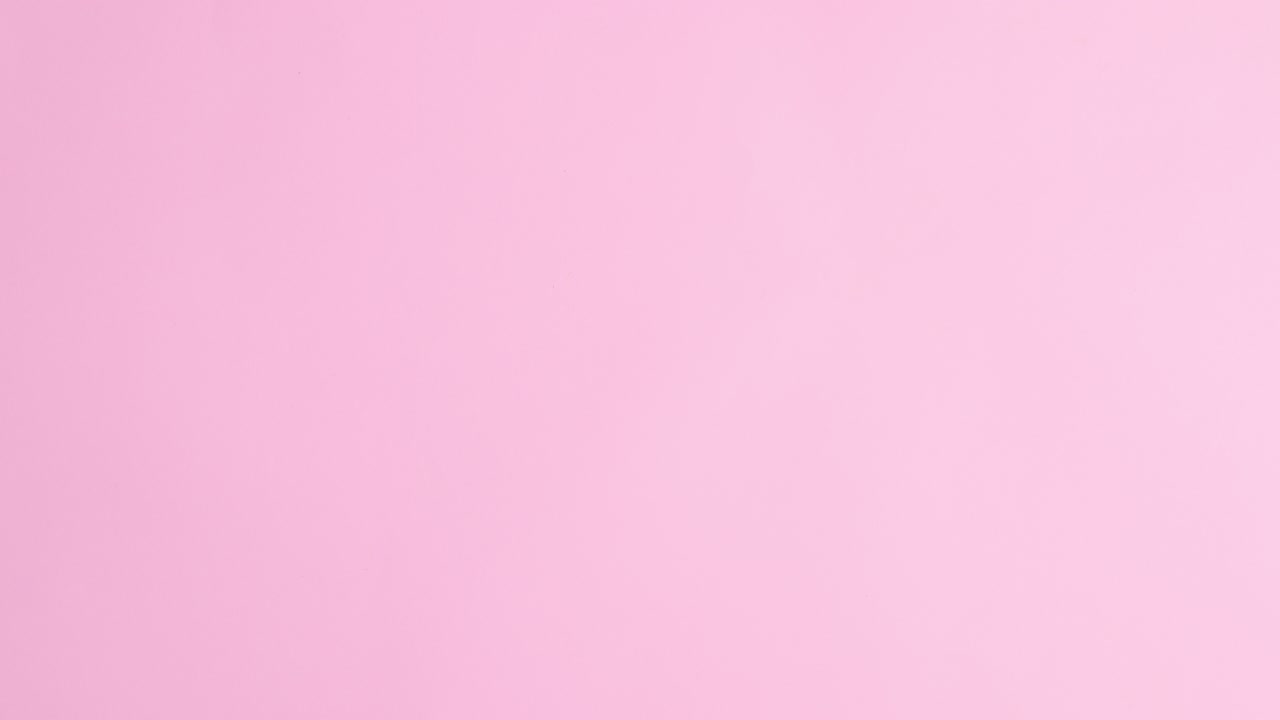 Fresh croissant and cup of coffee appear on pastel pink background. Stop motion