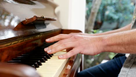 hombre tocando el piano en la sala de estar en casa 4k