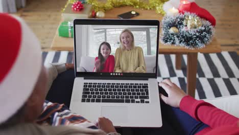 Afroamerikanische-Mutter-Und-Tochter-Nutzen-Laptop-Für-Weihnachtsvideoanruf-Mit-Der-Familie-Auf-Dem-Bildschirm