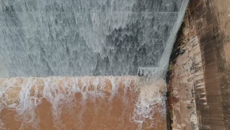 flood waters cascading over a dam wall from a drone 9